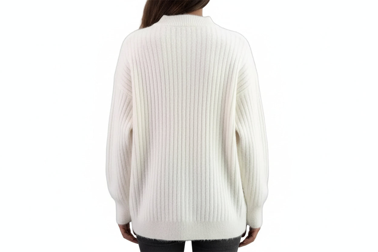 White ribbed sweater worn by a person with a blurred background